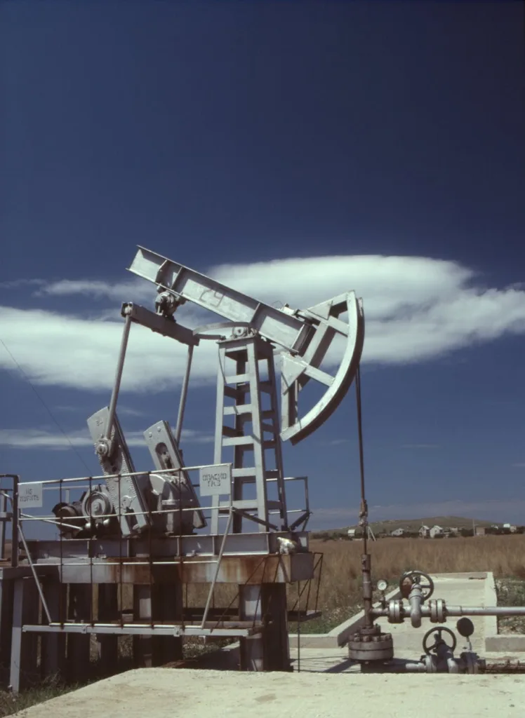 a gray steel pumpjack under blue sky