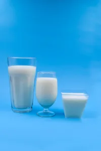 glasses of milk on blue surface