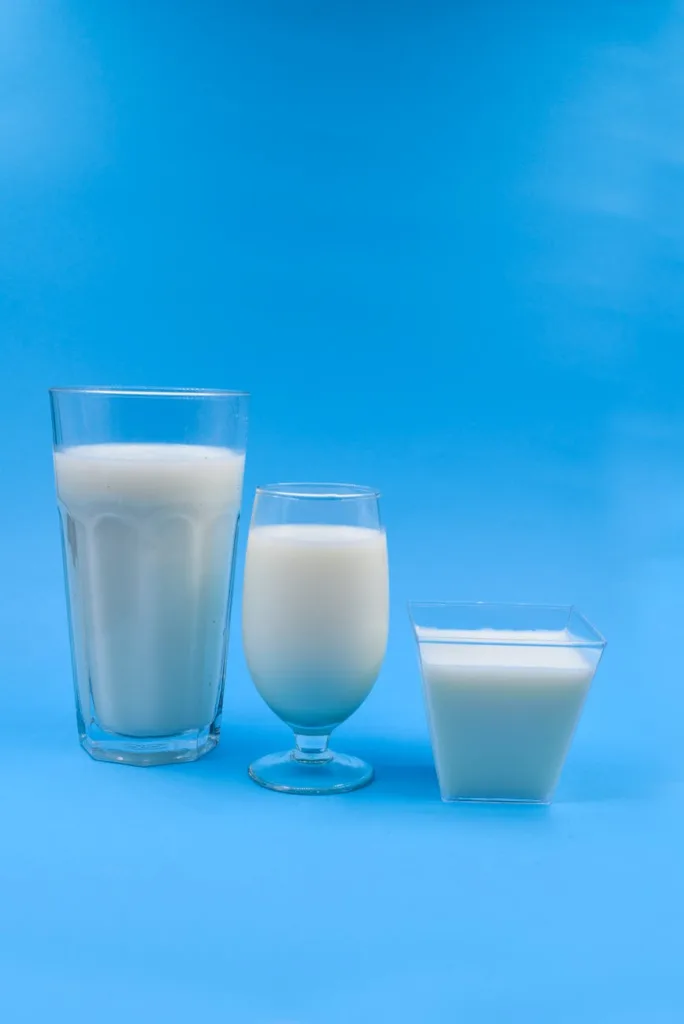 glasses of milk on blue surface