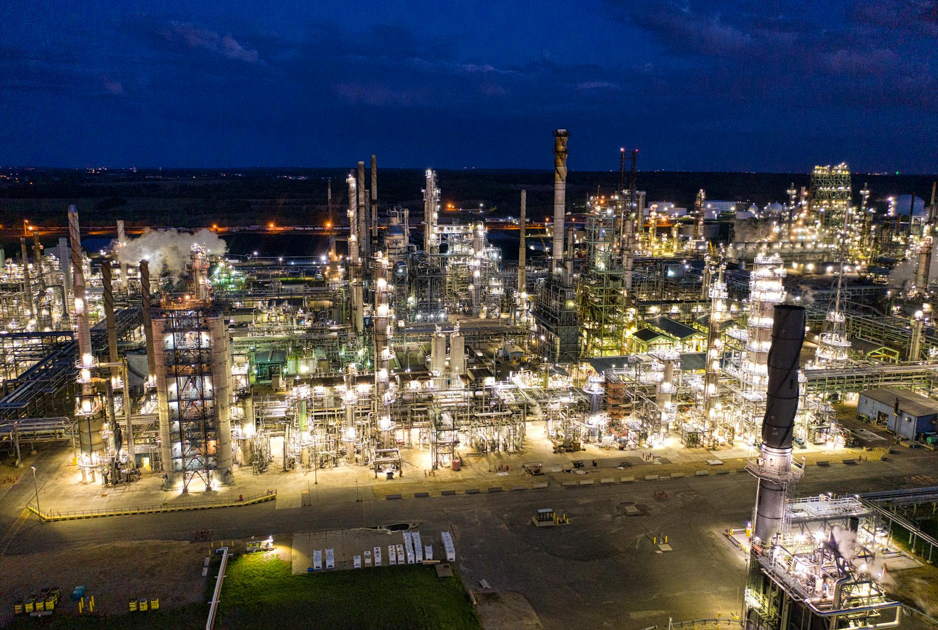 aerial view of an industrial plant with lights turned on during night time