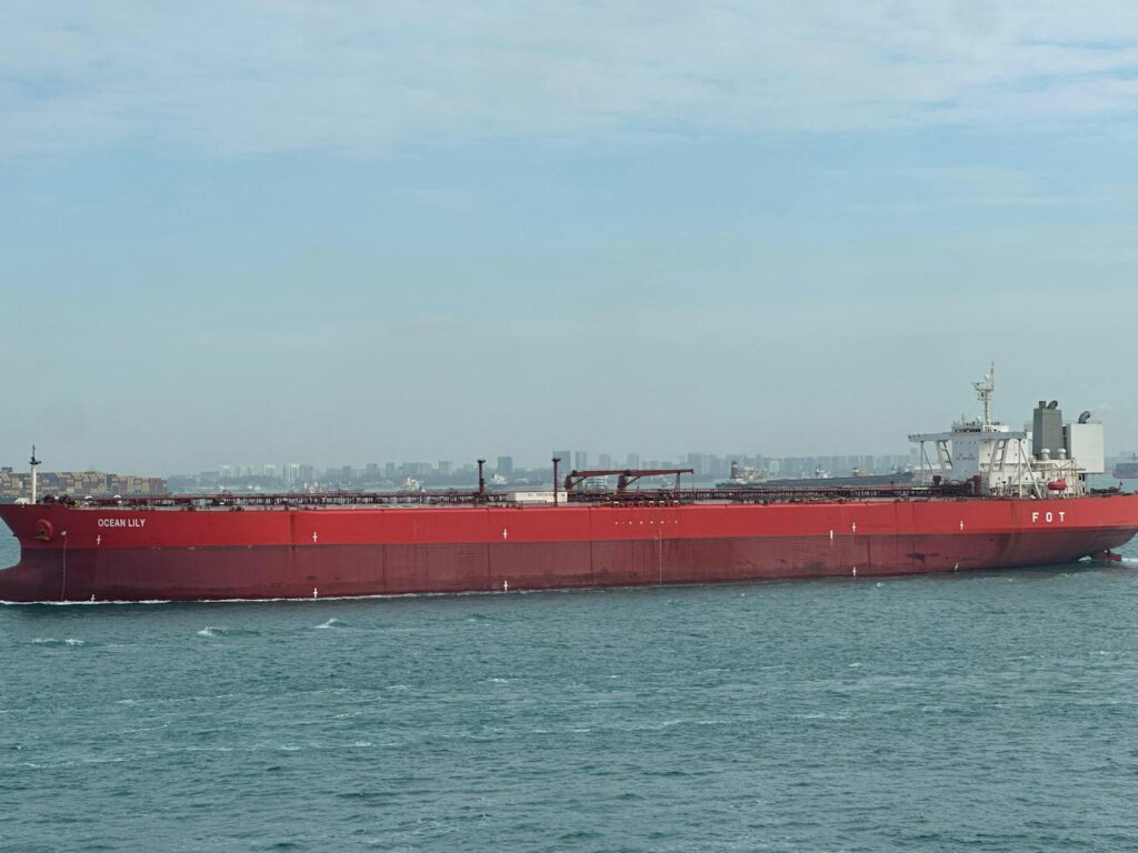 large red cargo ship in blue ocean