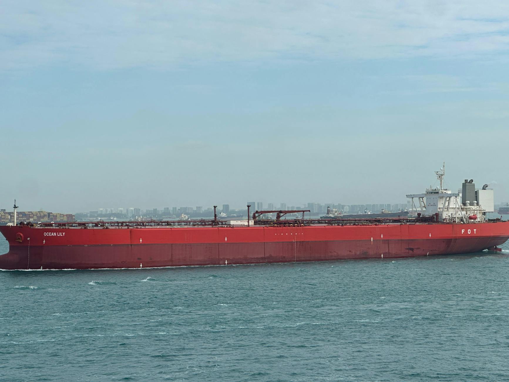 large red cargo ship in blue ocean