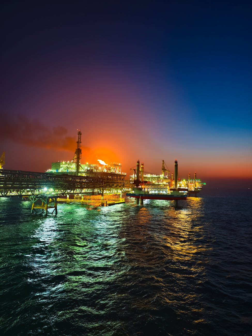 dramatic offshore oil rig at sunset